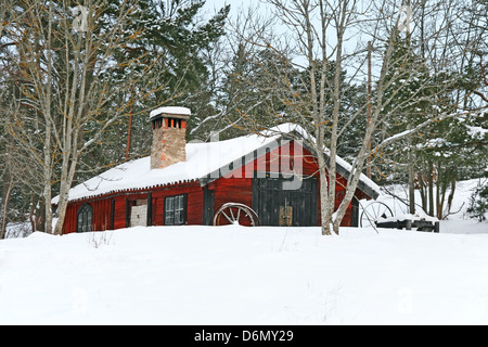 Vecchio rustico in legno rosso fienile nella neve. Inverno svedese. Foto Stock