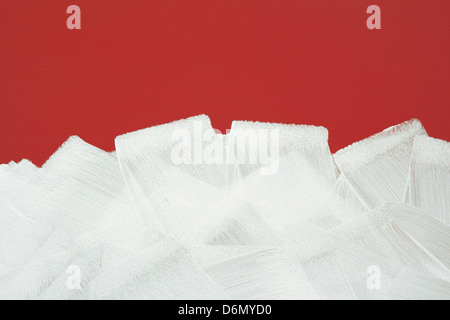 Rosso brillante muro dipinto in bianco con rullo di vernice. I tratti di pennello texture. Foto Stock
