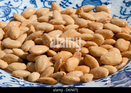 Almond - dadi, fritti salati mandorle sulla piastra Foto Stock