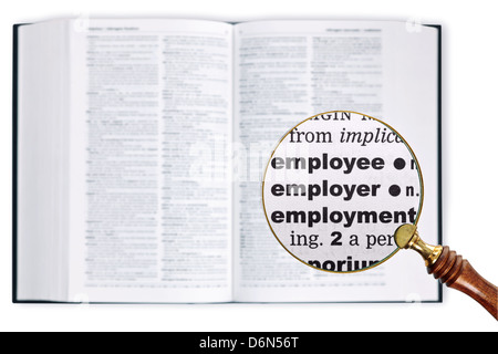 Una lente di ingrandimento detenute nel corso di un dizionario guardando le parole dipendente, datore di lavoro e di occupazione in scala ingrandita Foto Stock