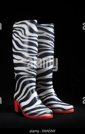 Moda Donna zebra-stile stivali di gomma isolato con sfondo nero girato in studio, acquistato in Ucraina Foto Stock