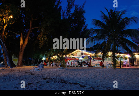 Holetown, Barbados, gli ospiti siedono la sera prima gli illuminati Surfside Ristorante Foto Stock