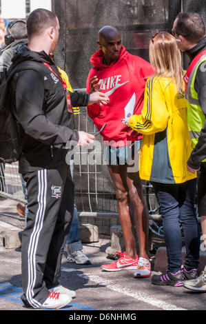 Londra, East Smithfield, 21 aprile 2013. Mo Farah, somale nato e Team GB di Olimpiadi doppia medaglia nel 5,000m e 000m a Londra 2012, indossa la sua felpa dopo aver terminato la sua corsa, appena prima di miglio 13. Prima della gara Farah aveva detto che egli ha voluto restare con la Elite Uomini Maratona fino a metà strada e ha fatto proprio questo. Foto Stock