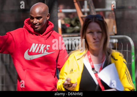 Londra, East Smithfield, 21 aprile 2013. Mo Farah, somale nato e Team GB di Olimpiadi doppia medaglia nel 5,000m e 000m a Londra 2012, indossa il suo sponsor felpa dopo aver terminato la sua corsa, appena prima di miglio 13. Prima della gara Farah aveva detto che egli ha voluto restare con la Elite Uomini Maratona fino a metà strada e ha fatto proprio questo. Foto Stock