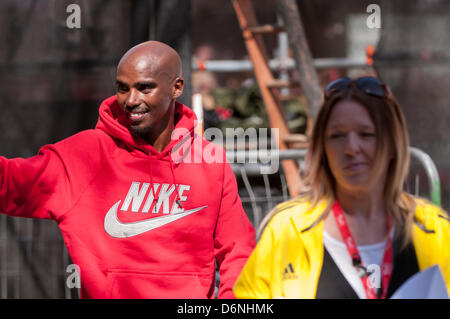 Londra, East Smithfield, 21 aprile 2013. Mo Farah, somale nato e Team GB di Olimpiadi doppia medaglia nel 5,000m e 000m a Londra 2012, indossa il suo sponsor felpa dopo aver terminato la sua corsa, appena prima di miglio 13. Prima della gara Farah aveva detto che egli ha voluto restare con la Elite Uomini Maratona fino a metà strada e ha fatto proprio questo. Foto Stock