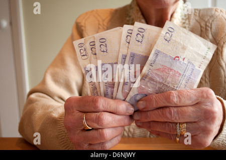 Donna anziana fanning venti pound note Foto Stock