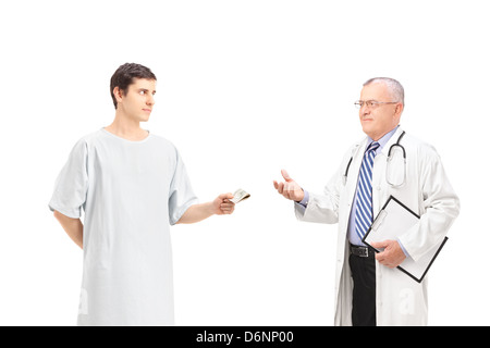 Paziente di sesso maschile che offre tangenti ad un medico maturo, isolato su sfondo bianco Foto Stock