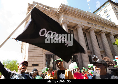 L'uomo sventola una bandiera occupano in un raduno di fronte alla Bank of America building, Washington DC Foto Stock