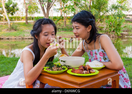 Asian Girls Thai insieme picnic accanto alla palude. Foto Stock