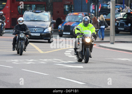 Due motociclisti e il traffico che viaggia lungo una strada a Londra, Inghilterra. Foto Stock