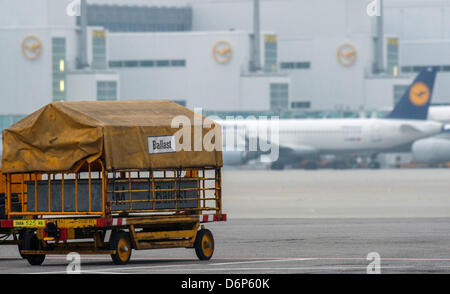 Svuotare carrelli per bagagli stare accanto a piani della compagnia Lufthansa sulla pista dell'aeroporto di Monaco di Baviera, Germania, il 22 aprile 2013. È la seconda tornata di scioperi, iniziata come reazione a un continuo di contrattazione collettiva e i negoziati sulle condizioni di lavoro di circa 33.000 tecnici e gli assistenti di volo. Foto: Marc Mueller Foto Stock