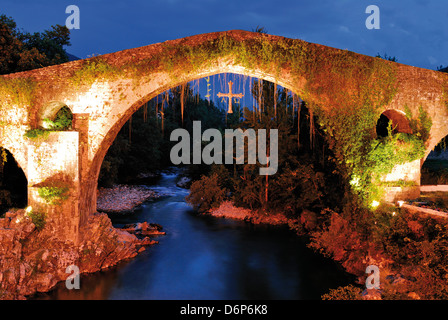 Spagna Asturie: orologio notturno illuminato Puente Romana in Cangas de Onís Foto Stock