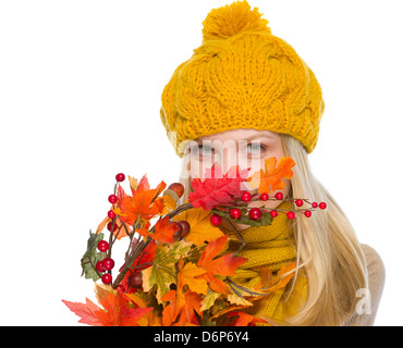 Ragazza nel cappello e sciarpa nascondersi dietro a bouquet di autunno Foto Stock