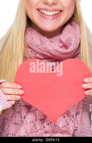 Primo piano su a forma di cuore ad una cartolina in mano della ragazza in abbigliamento invernale Foto Stock