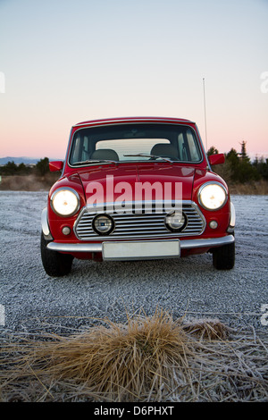 Di fronte a un classico rosso Mini (1990) in una fredda giornata invernale. Tutti i marchi e i loghi sono stati rimossi. Foto Stock