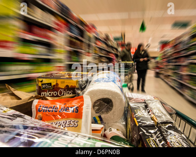 Prodotti in un carrello mobile lungo i corridoi di un supermercato Foto Stock