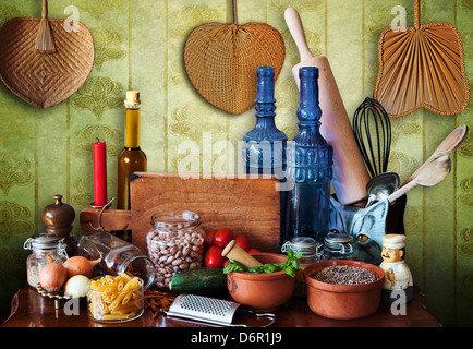 Cucina vita ancora in stile mediterraneo, mattarello, bottiglie di vetro, verdure, tagliatelle, le cipolle, legumi, i pomodori e le erbe Foto Stock