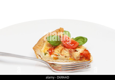Formaggio, pomodori e basilico quiche su una piastra con una forcella Foto Stock