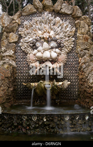 Una fontana sgorga dalla bocca di un viso grottesco fatto interamente di conchiglie. Una bizzarra fontana nel Parc de Sceaux vicino a Parigi, Francia. Foto Stock