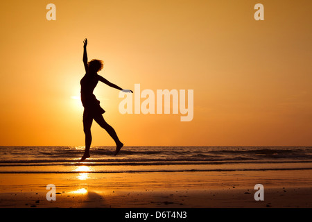 Silhouette di donna felice salto sulla spiaggia, uno stile di vita sano Foto Stock