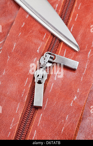 Sarto cesoie e zip guide su dettagli di pelle marrone pattern Foto Stock