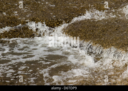 Le fasi della caduta in acqua, piccole cascate su un veloce che scorre il fiume. Un sottile strato di acqua contro la pietra Foto Stock