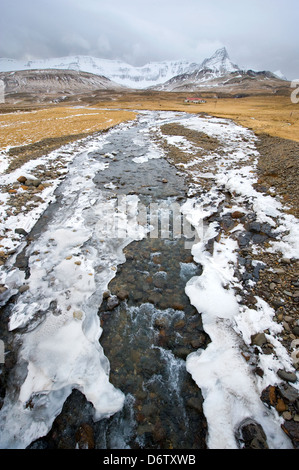 Un piccolo fiume galleggiando giù dalle montagne in Islanda in inverno Foto Stock