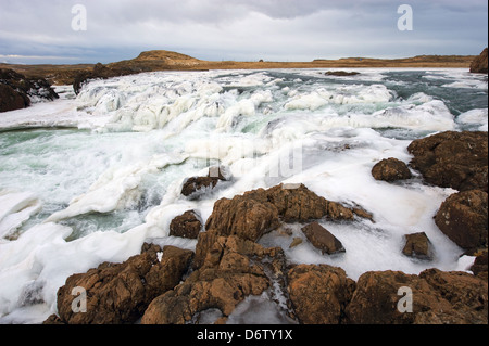Una cascata ghiacciata in un fiume selvaggio in Islanda in inverno Foto Stock