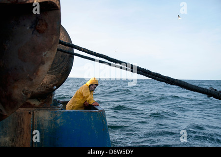 Pescatore tira indietro dragger net sulla pesca a strascico. Stellwagen banche, New England, Stati Uniti, Oceano Atlantico settentrionale Foto Stock