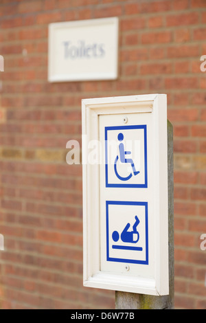 Un disabile baby modificare cambiando camera wc toilette di legname di legno segno avviso Foto Stock