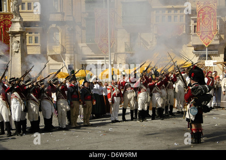 Gli uomini maltesi vestiti come soldati della guarnigione francese prendono parte alla rievocazione storica dell'assalto dei francesi sotto Napoleone (1798-1800) e all'arrivo degli inglesi che hanno aiutato a battere i francesi durante il Carnevale maltese nell'isola di Malta Foto Stock