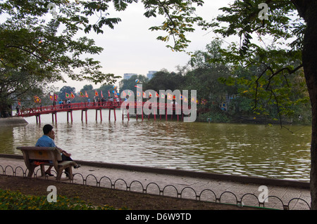 Orizzontale di un ampio angolo di visione di un asiatico giovane godendo la vista del Huc bridge, Thê Húc ponte che attraversa il lago Hoan Kiem in Han Foto Stock