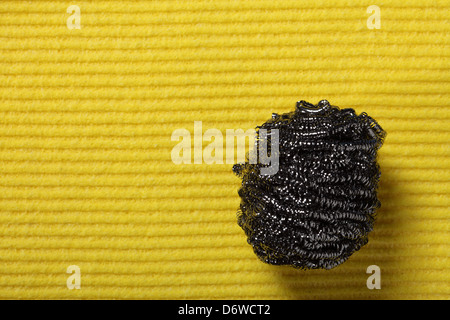 Spugna gialla sfondo e piatto in acciaio inossidabile scourer Foto Stock