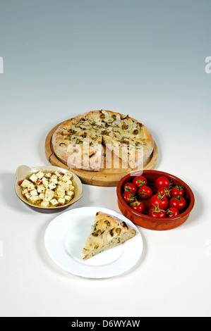 Italian verde oliva, cipolla e focaccia al rosmarino, il formaggio Feta e pomodori ciliegia contro un grigio e sfondo bianco. Foto Stock