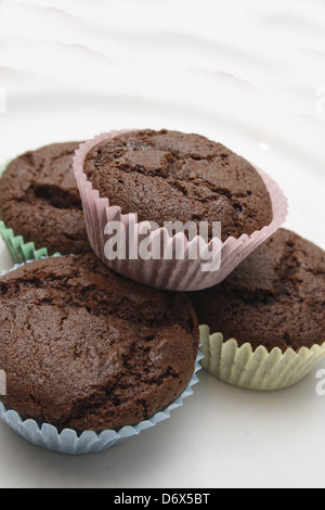 Tortini di cioccolato in multicolore di pirottini sulla piastra bianca Foto Stock