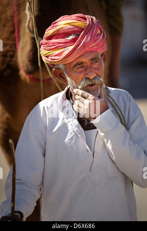 Ritratto di india uomo camel rider indossando turbante rosso, Bishnoi, India Foto Stock