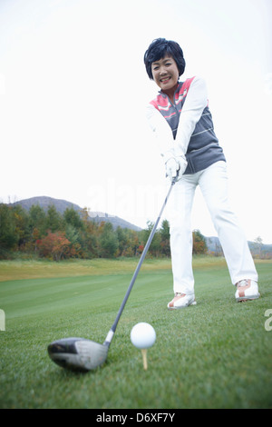 Una donna per giocare a golf in un campo da golf Foto Stock