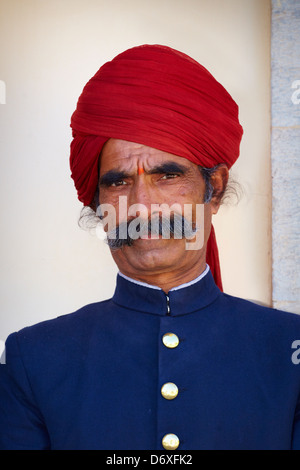 Ritratto di una India guard uomo con i baffi indossando turbante rosso, City Palace di Jaipur, Rajasthan, India Foto Stock