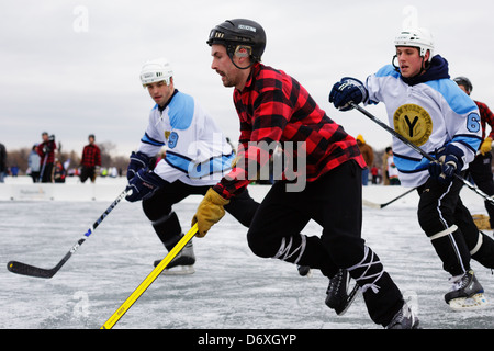 I giocatori di competere nel corso di una partita in Stati Uniti Pond Hockey campionati sul lago Nokomis il 19 gennaio 2013. Foto Stock