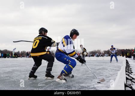 I giocatori competono durante una partita agli U.S. Pond Hockey Championships sul lago Nokomis. Minnesota, Stati Uniti. Foto Stock