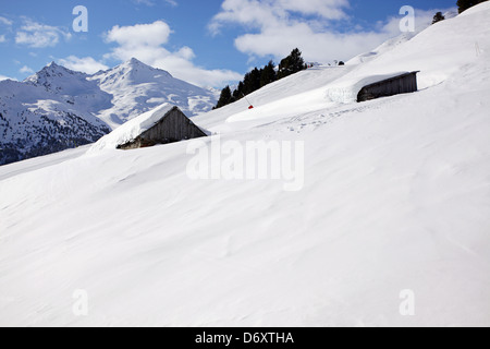 Snowy scena con due baracche di legno coperto di neve. Sciare a Méribel, Francia Foto Stock