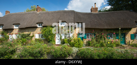 Tradizionale caratteristico cottage con il tetto di paglia, rose-coperti in Clifton Hampden in Oxfordshire, Regno Unito Foto Stock