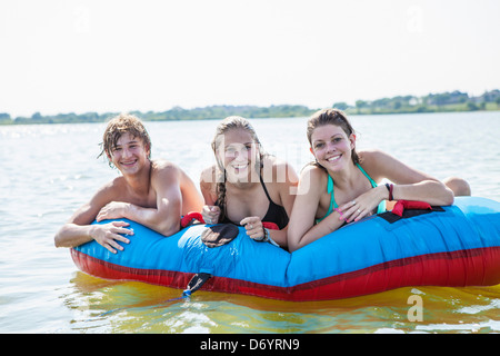 Stati Uniti d'America, Texas, Lewisville, tre adolescenti circa a correre sul tubo interno nel lago Lewisville Foto Stock