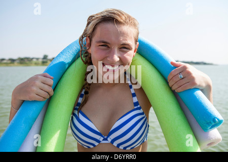 Stati Uniti d'America, Texas, Lewisville, ragazza adolescente a lago con due paste intorno a lei le spalle Foto Stock