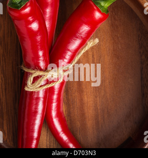 Mazzetto di peperoncino rosso, nella ciotola di legno vicino fino Foto Stock