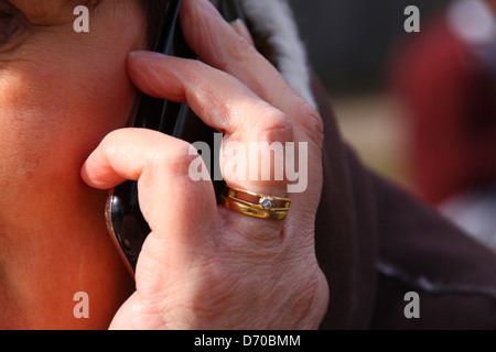 Persone di mezza età donna sposata tiene iPhone all'orecchio Foto Stock