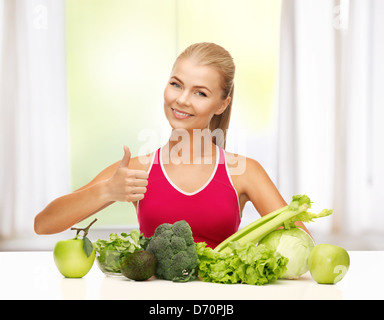 La donna mostra Thumbs up con alimenti biologici Foto Stock