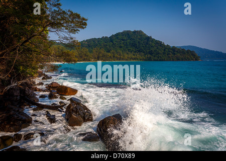 Gli spruzzi di onde sulla spiaggia rocciosa Foto Stock