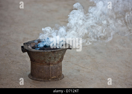 Stove carbone che brucia, Antananarivo, Madagascar Foto Stock