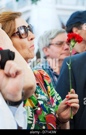 Lisbona, Portogallo. Xxv Aprile, 2013. Il 25 di aprile festa a Lisbona il Largo do Carmo. Donna che mantiene un garofano guardando gli interventi al di fuori del quartiere GNR Foto Stock